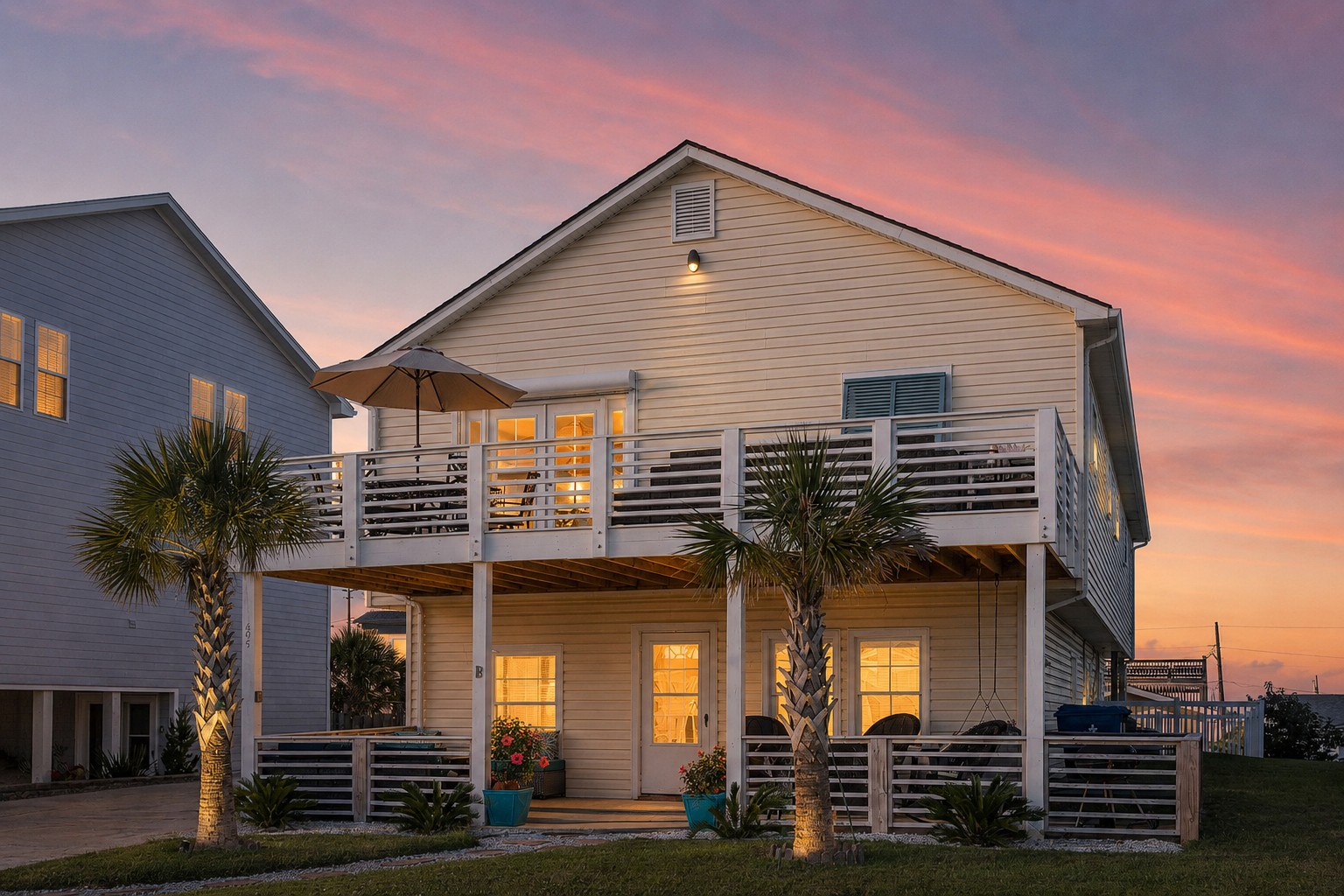205 Barefoot Lane at sunset with upper and lower porches lit