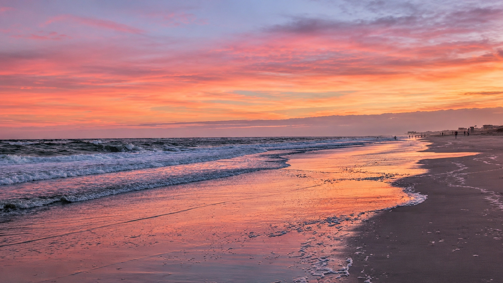 Sunset light reflecting on the wet sand along the shoreline