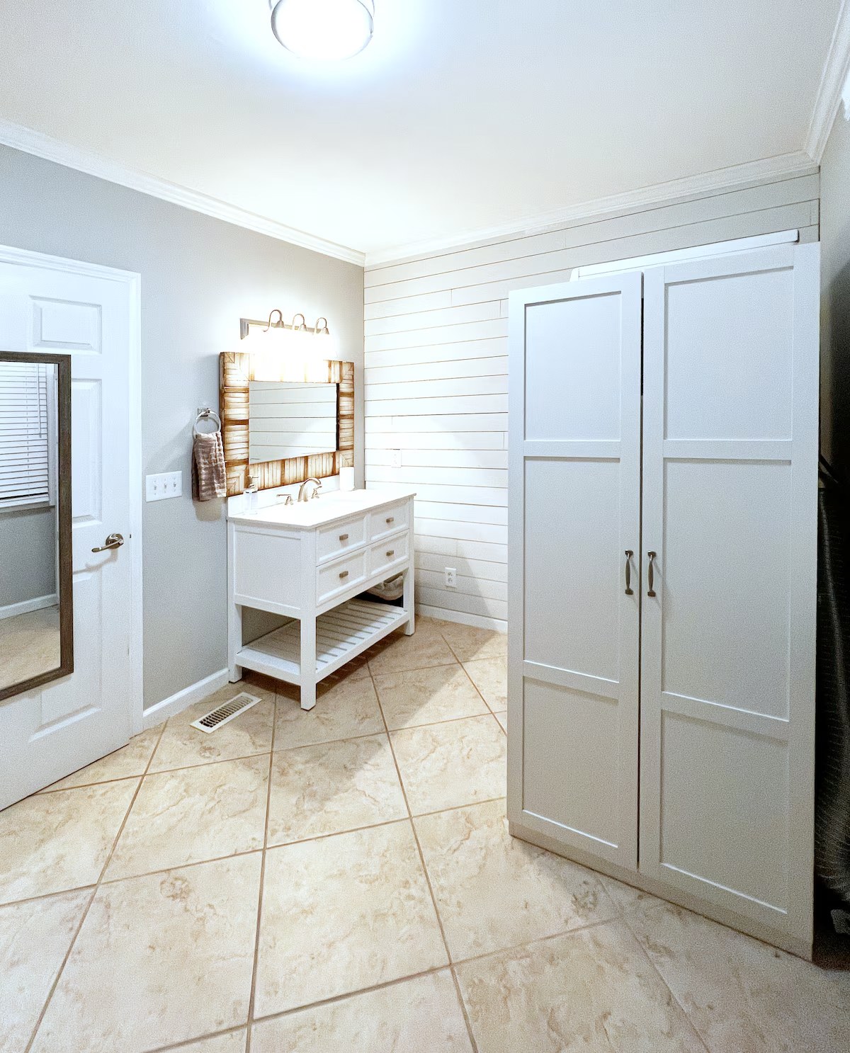 Main bathroom vanity with tall linen closet doors