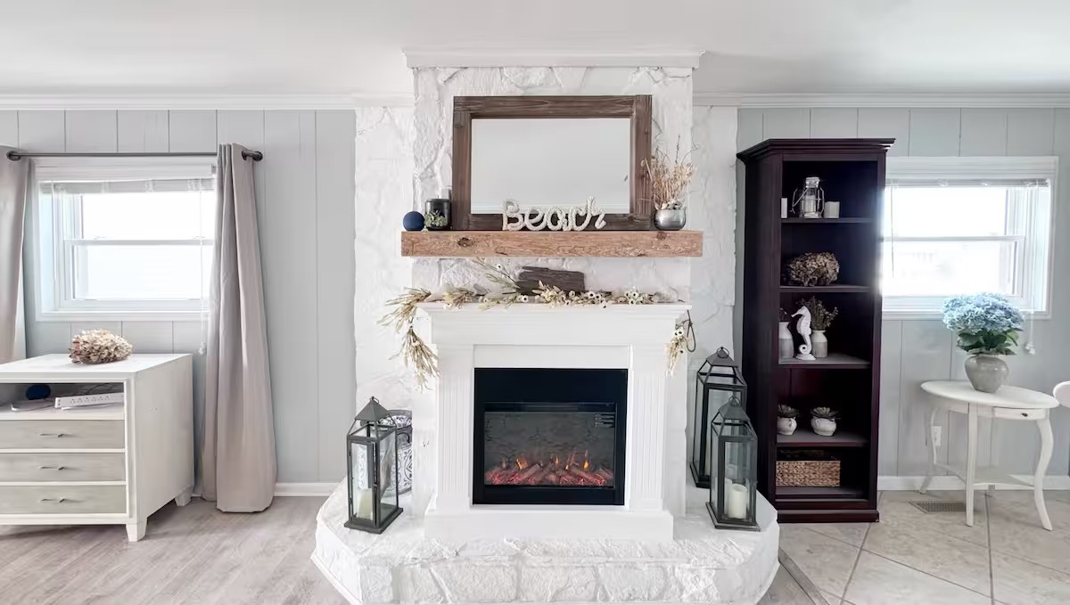Close-up of the fireplace mantel with 'Beach' sign and dark wood bookshelf