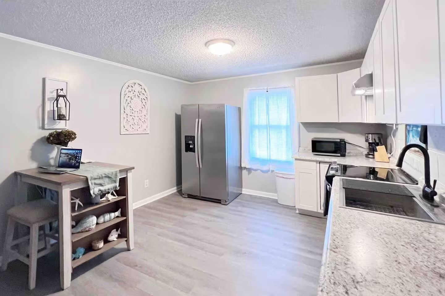 Kitchen with breakfast bar island and stainless refrigerator